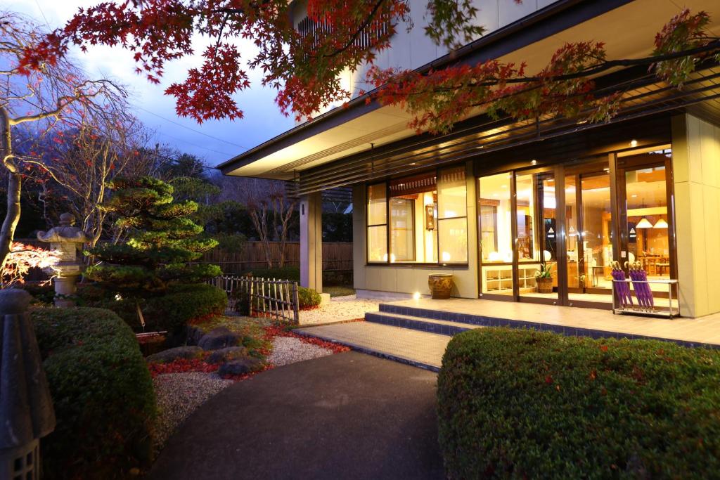 駒根的住宿－山吹旅館，一座拥有许多窗户和花园的建筑