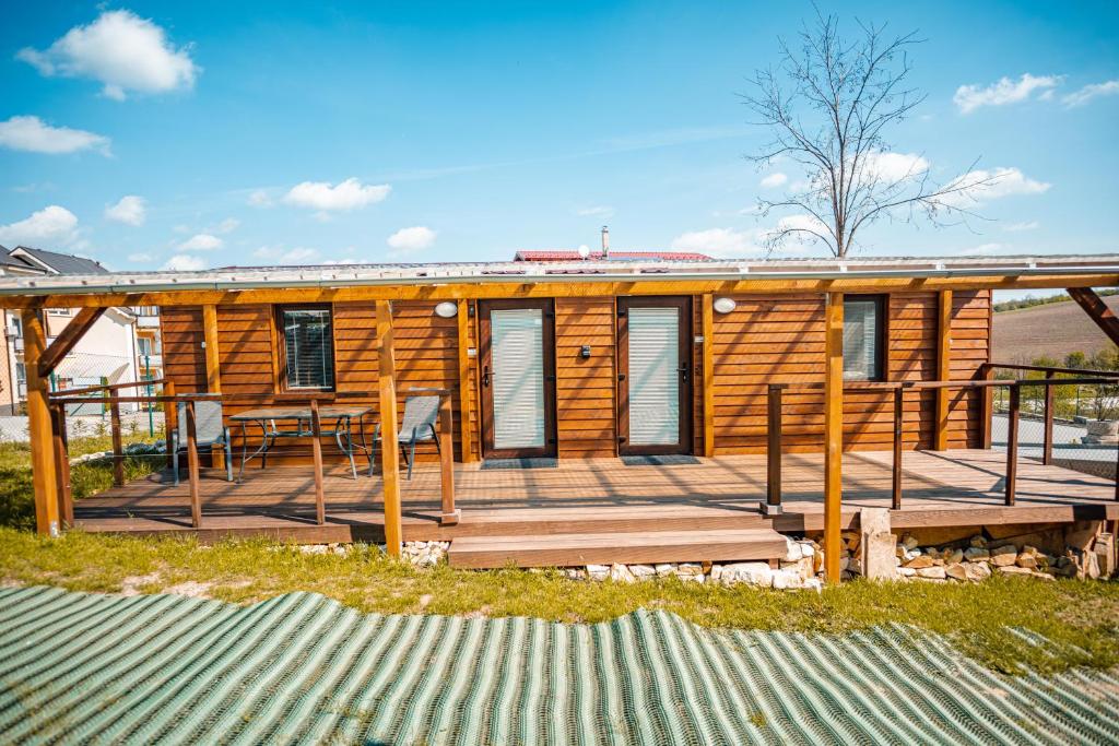 una cabina in legno con terrazza, tavolo e sedie. di Podhájska - GABIONKA a Podhájska