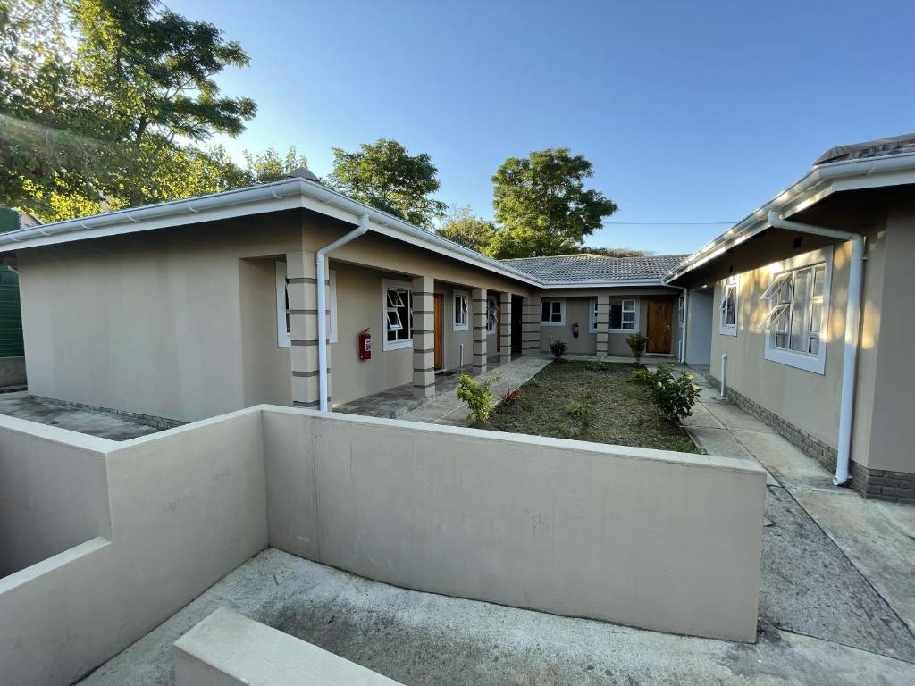 ein Haus mit einem weißen Zaun davor in der Unterkunft Hinterland Lodge in Ulundi