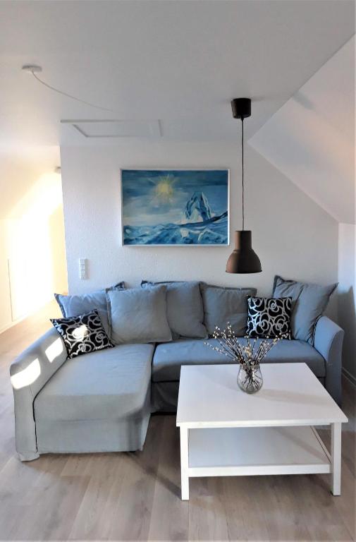 a living room with a blue couch and a white table at Nabo til domkirken in Viborg