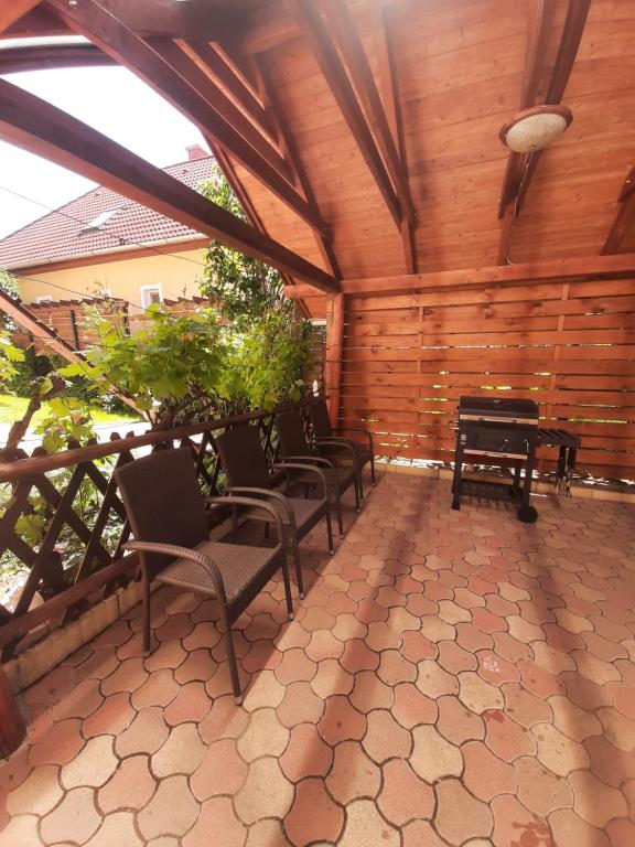 a screened porch with chairs and a piano at Forrás-hegyi Apartman in Felsőörs
