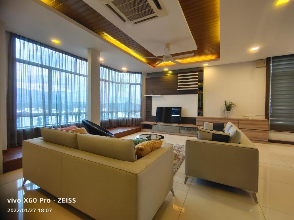 a living room with two couches and a kitchen at Sky Garden Penthouses in Chemor