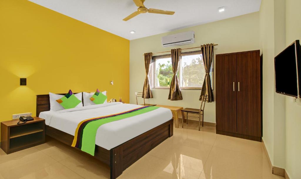 a bedroom with a large bed and a flat screen tv at Treebo Trend La Paradise in Mahabaleshwar