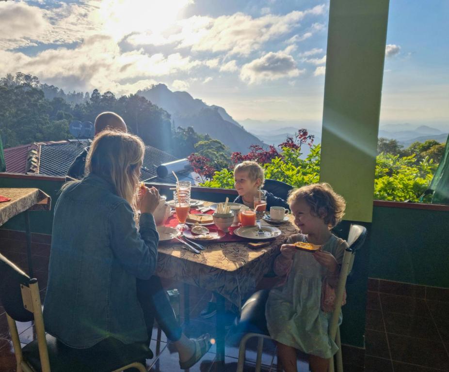 a group of people sitting at a table eating food at Hilltop Guest House in Ella