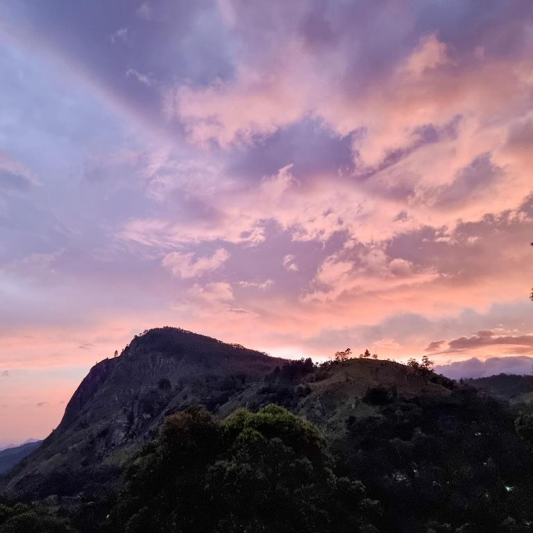 a mountain with a sunset in the sky at Hilltop Guest House in Ella