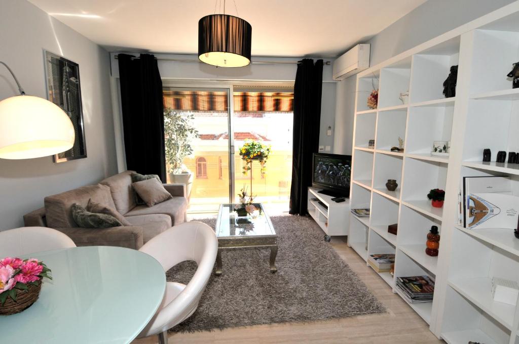 sala de estar con mesa y sofá en IPANEMA Residence Le Vendome, en Cannes