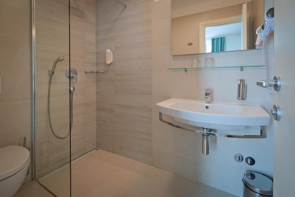 a bathroom with a sink and a shower at Hotel Bor in Krk
