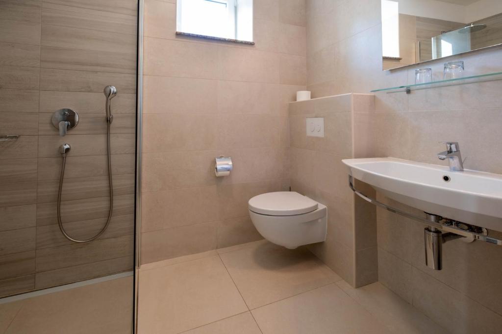 a bathroom with a shower and a toilet and a sink at Hotel Bor in Krk