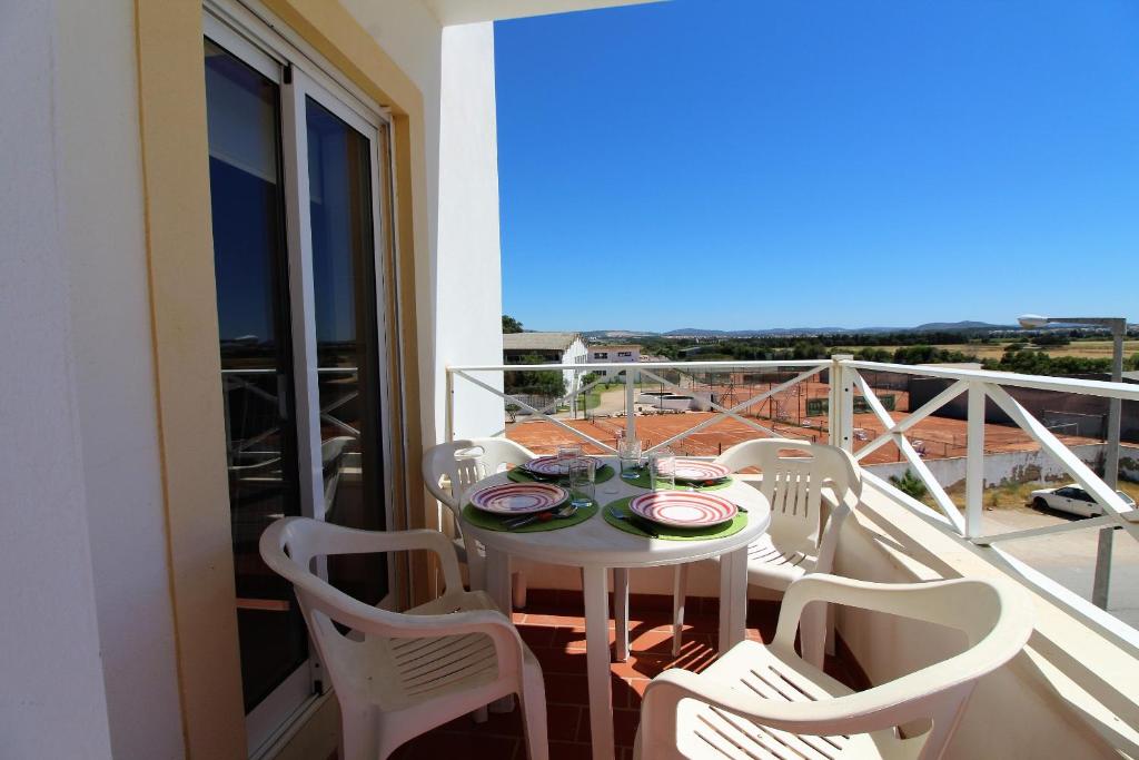 a table and chairs on a balcony with a view at Falesia Beach Apartment in Albufeira