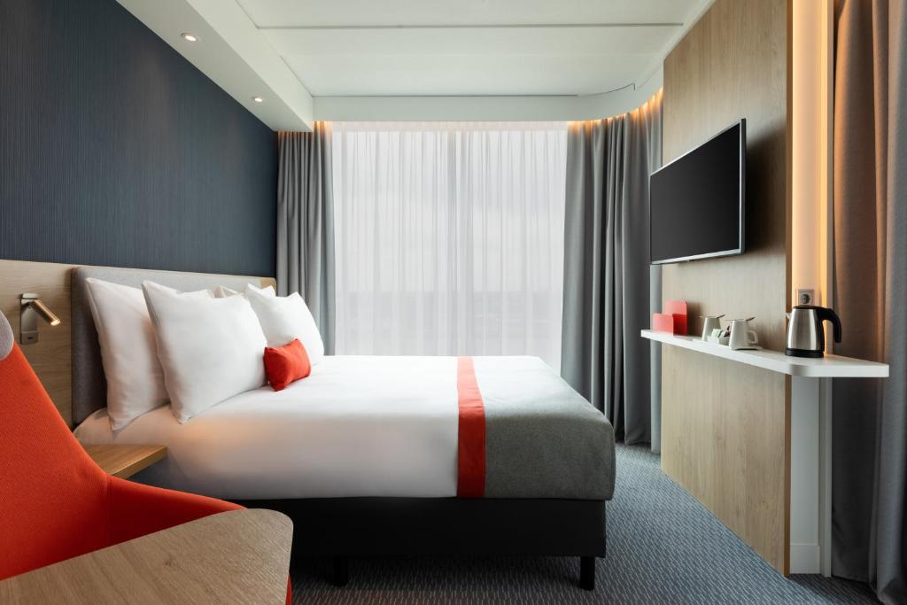a hotel room with a bed and a television at Holiday Inn Express Amsterdam - North Riverside by IHG in Amsterdam