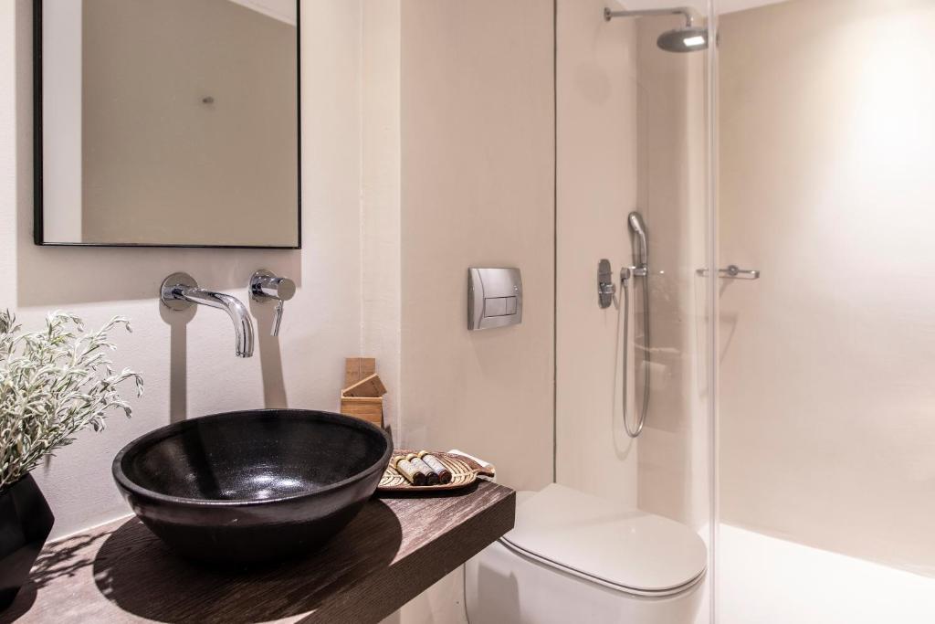 a bathroom with a black bowl sink and a shower at Nimbus My Aktis in Super Paradise Beach