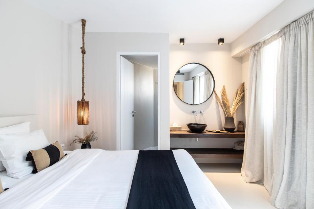 a bedroom with a large bed and a mirror at Nimbus My Aktis in Super Paradise Beach