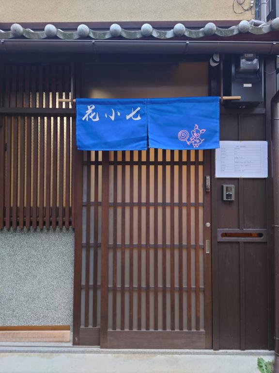 a door to a building with a blue flag on it at 柏 花小七 Haku Flowers Seven in Kyoto