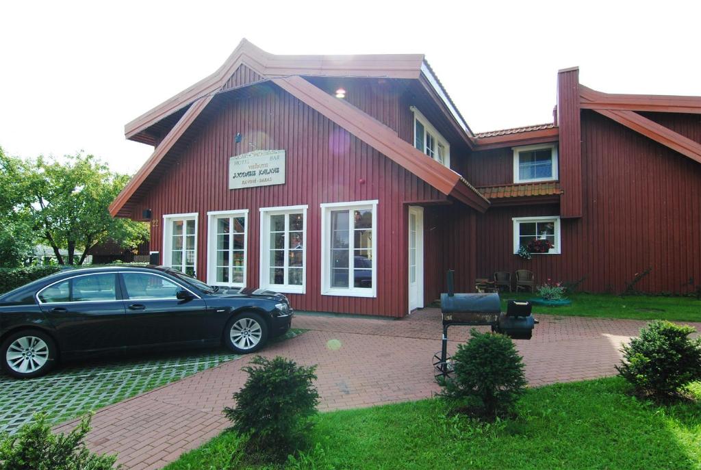 a black car parked in front of a red building at Juodasis Kalnas in Juodkrantė