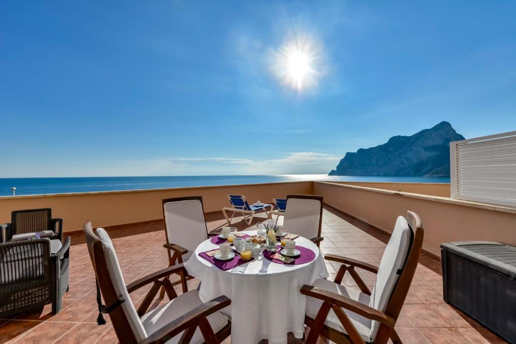 a table on a balcony with a view of the ocean at Villas Guzman - Apartamento Tramontana in Calpe
