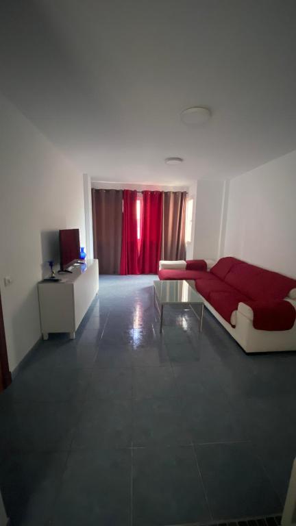 sala de estar con sofá rojo y cortina roja en Apartamento Islas Malvinas 39, en Vecindario