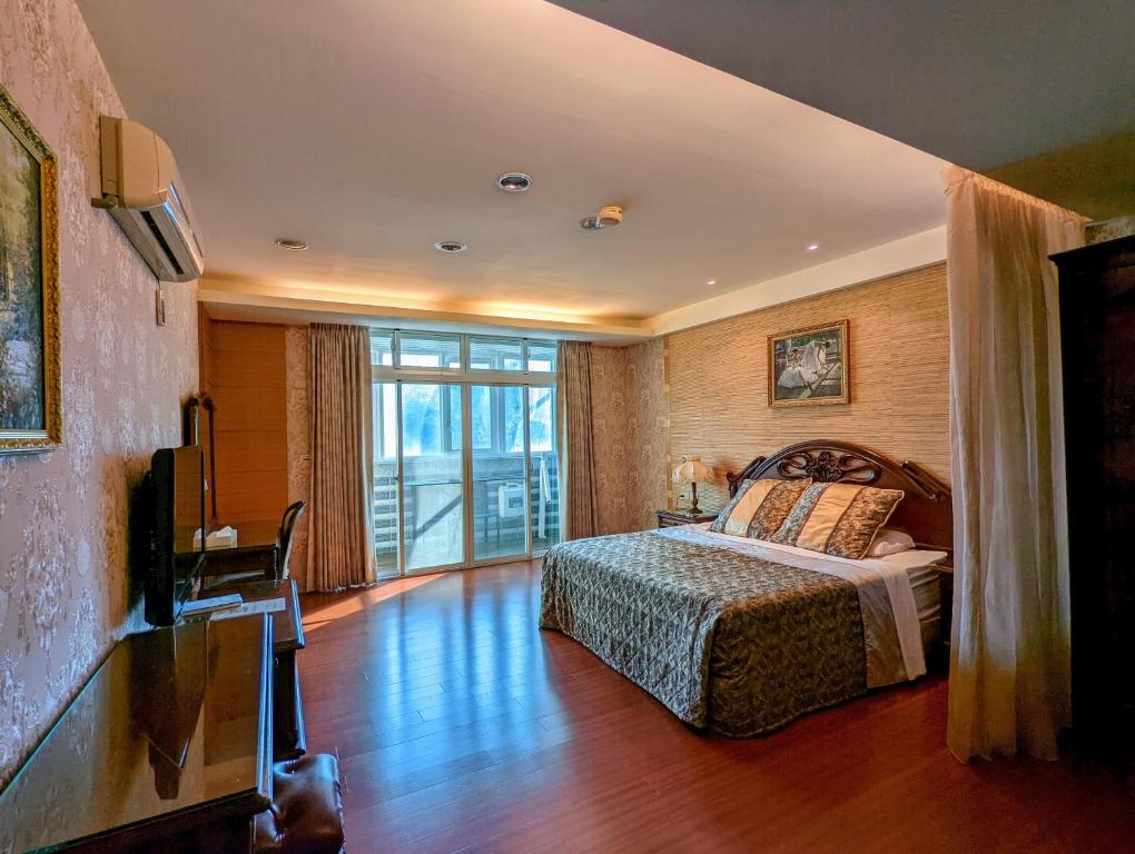 a bedroom with a bed and a large window at Champs Yazuh B&amp;B in Jiji