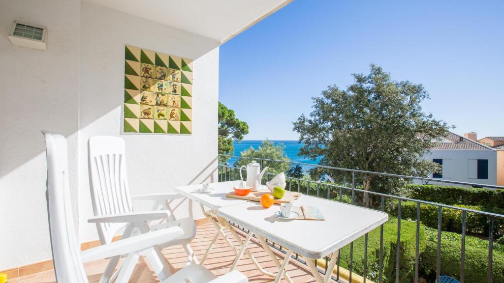 a white balcony with a white table and chairs at Roc 1D - Calella de Palafrugell in Calella de Palafrugell
