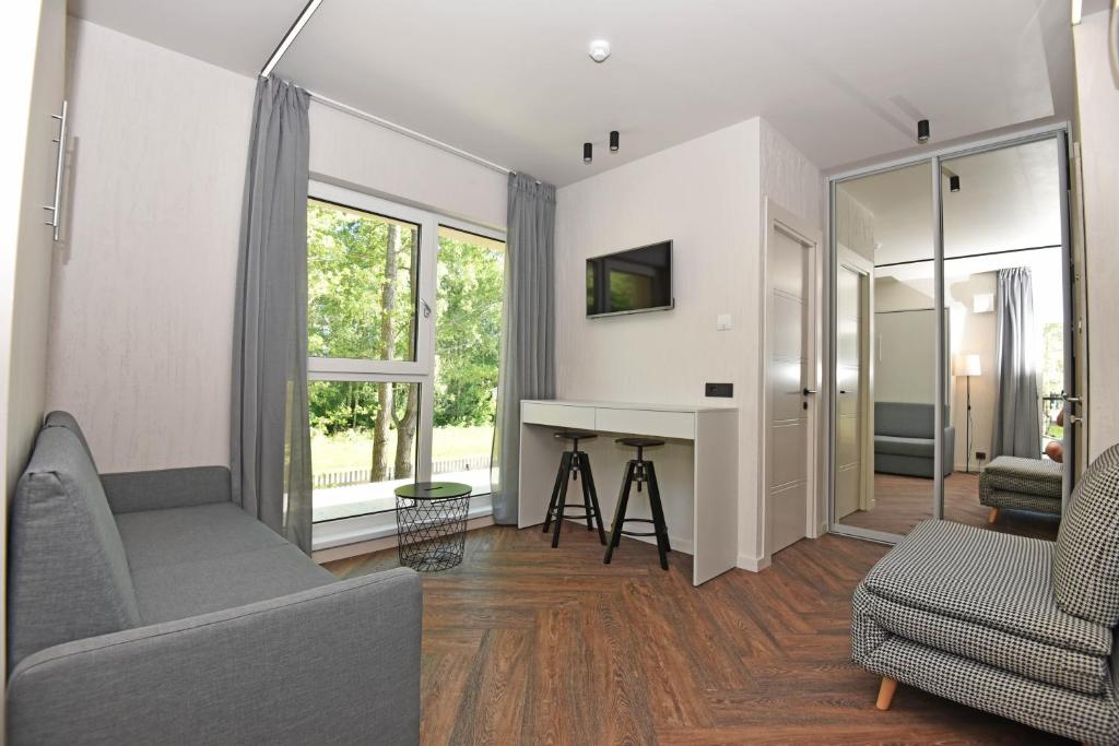 a living room with a couch and a desk at Čiki Puki Purslai in Palanga