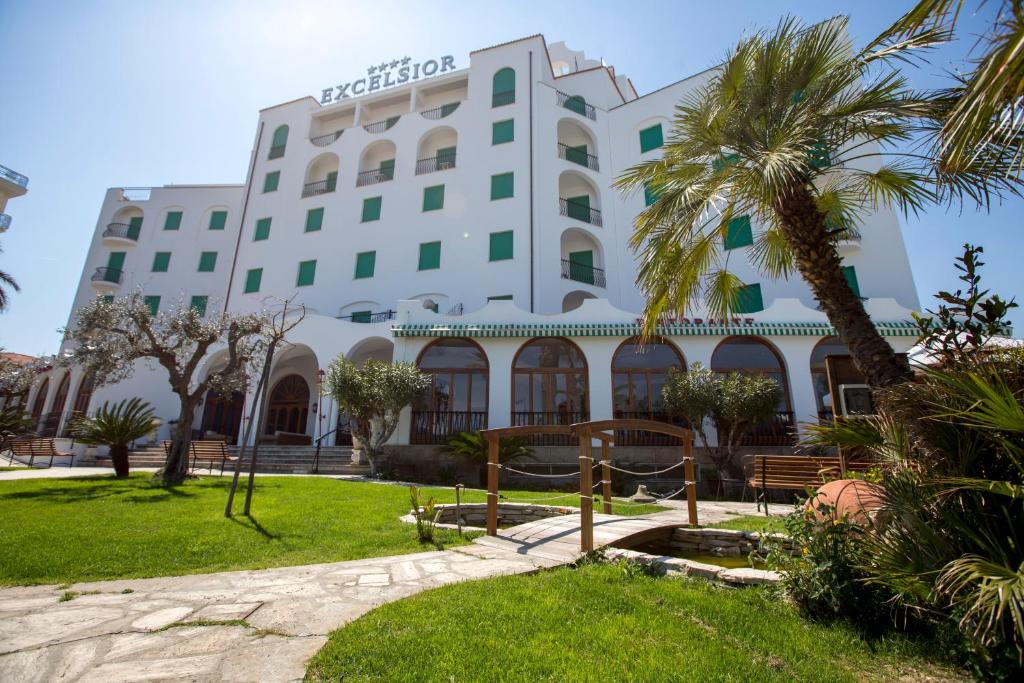 a hotel with a palm tree in front of it at Grand Hotel Excelsior in San Benedetto del Tronto