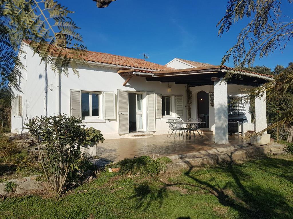 Ein weißes Haus mit einer Terrasse und einem Tisch in der Unterkunft CARINA in Solaro