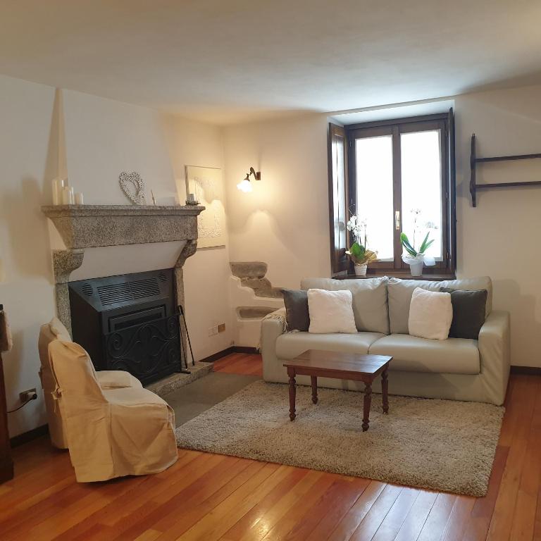 uma sala de estar com um sofá e uma lareira em Appartamento Dimora in Piazza -Locazione Turistica Santa Maria Maggiore em Santa Maria Maggiore