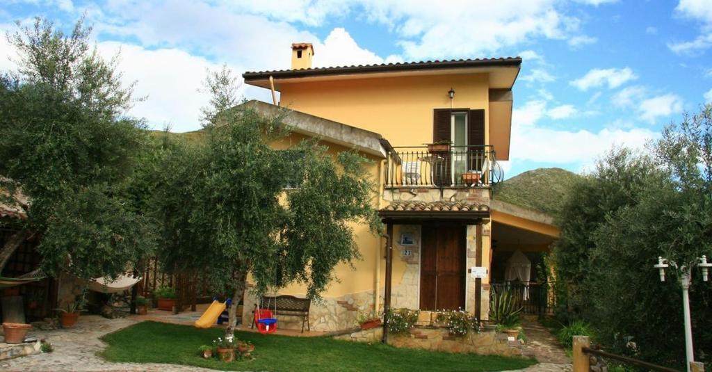 a large yellow house with a balcony and a yard at Buenavistasurfmed in Itri