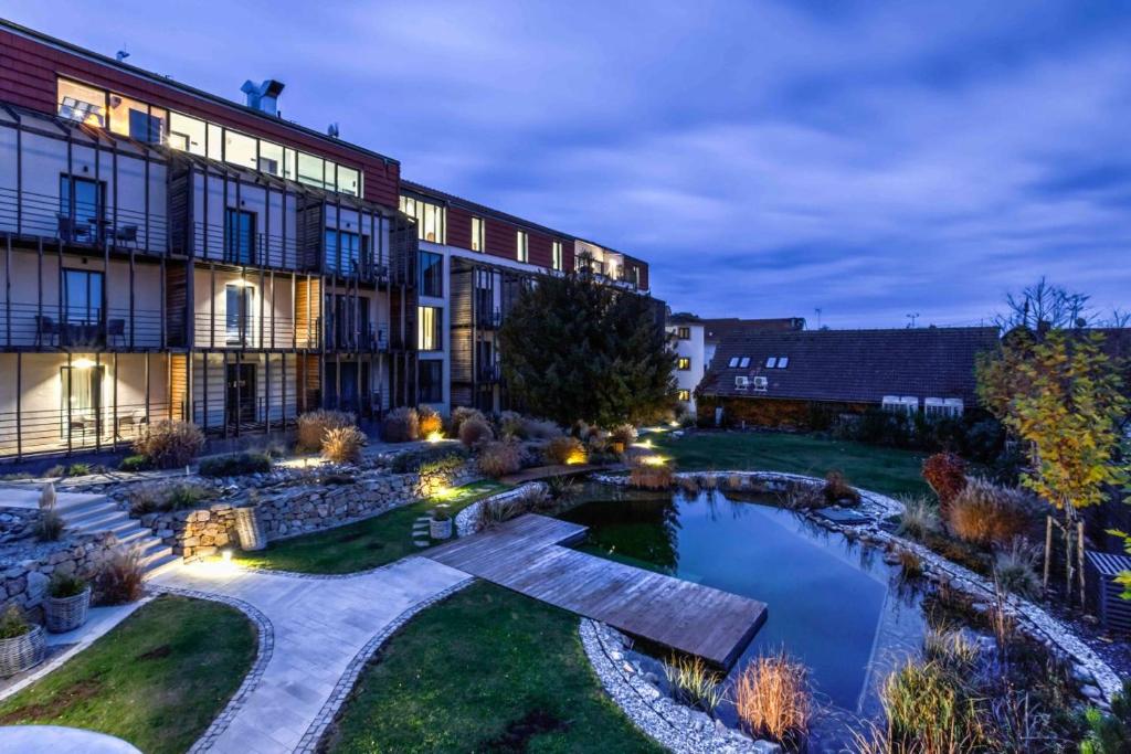 een uitzicht op een gebouw met een vijver in de tuin bij Wellness Hotel Volarik in Mikulov