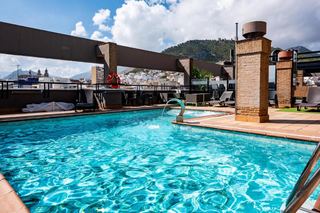 a swimming pool with a large swimming pool next to a building at Hotel Condestable Iranzo in Jaén