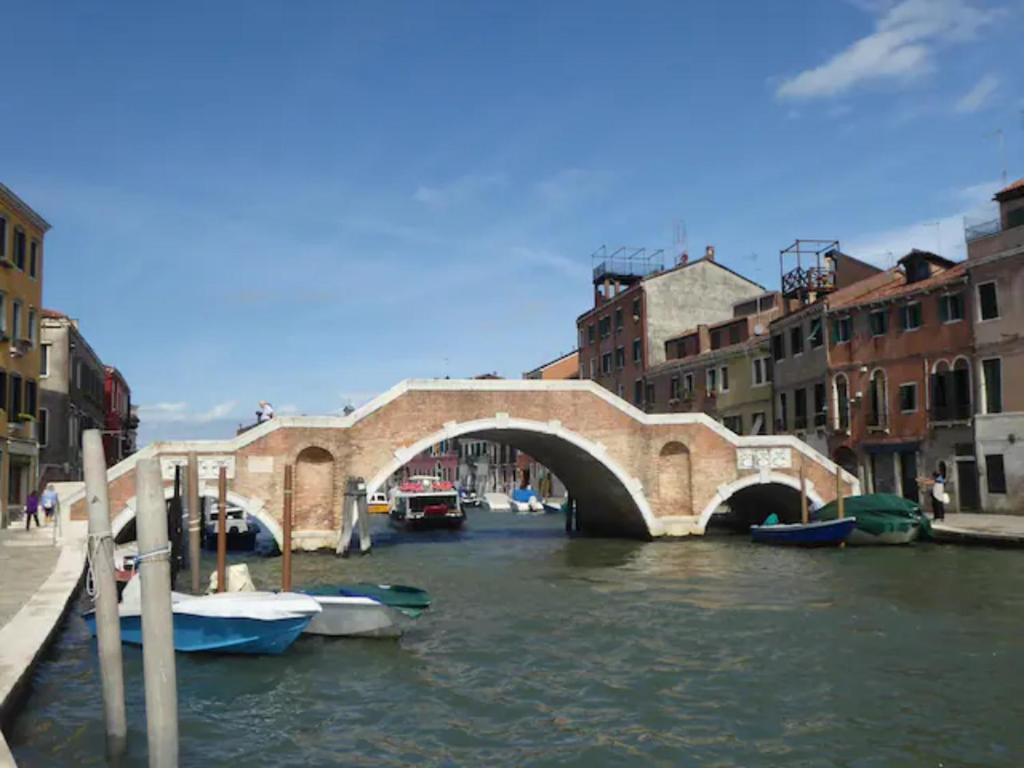 uma ponte sobre um canal com barcos na água em A due passi dall'antico Ghetto, sestiere di Cannaregio em Veneza