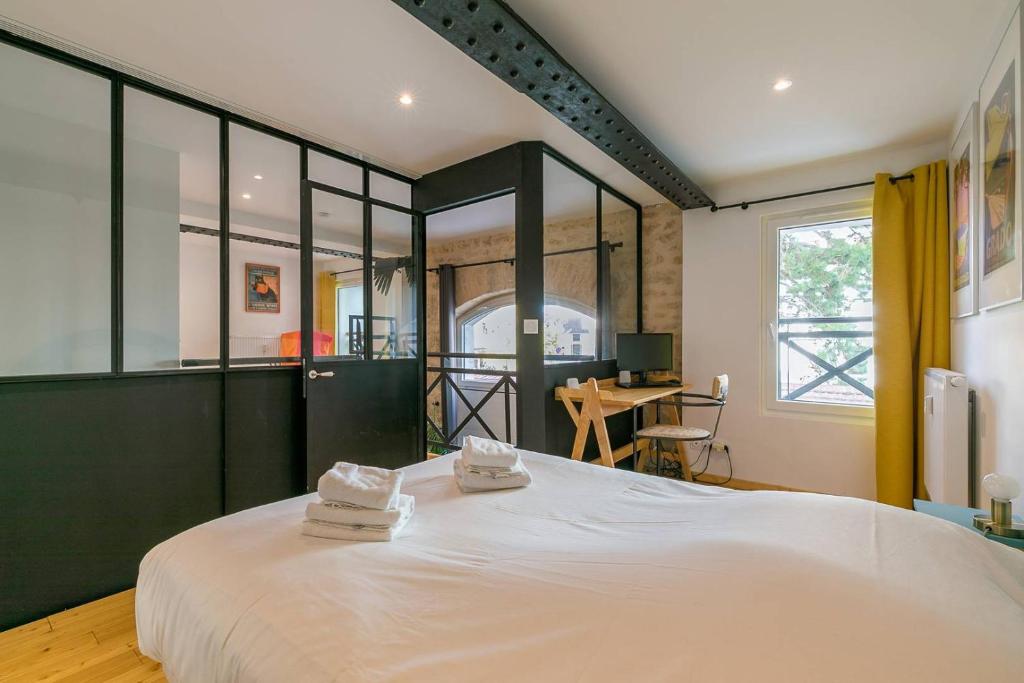 une chambre avec un grand lit avec deux serviettes dessus dans l'établissement Le Corbeau et le Homard, un vrai havre de paix, à Dijon