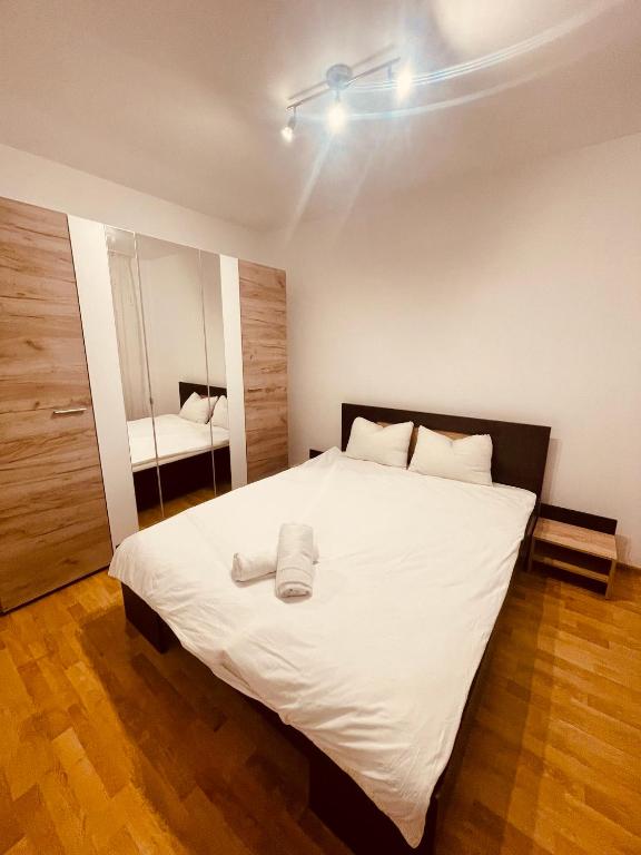 Schlafzimmer mit einem großen weißen Bett und einem Spiegel in der Unterkunft Joy City Stay Angela Sava 6 in Timişoara
