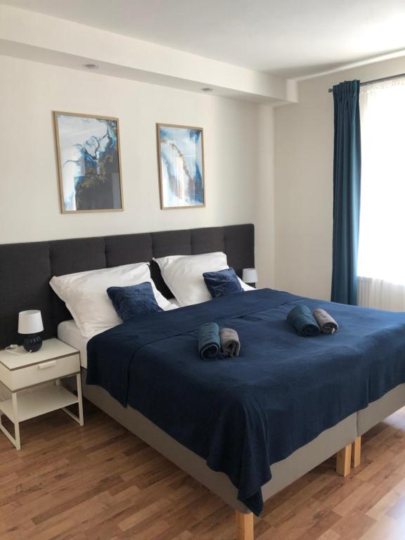 1 dormitorio con 1 cama grande con sábanas y almohadas azules en Penzion Nový Svět, en Krásno