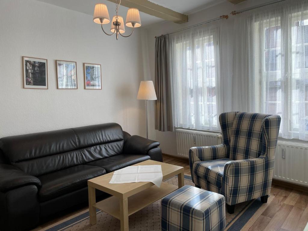 - un salon avec un canapé en cuir et une chaise dans l'établissement Apartment mit Terrasse No1, à Quedlinbourg