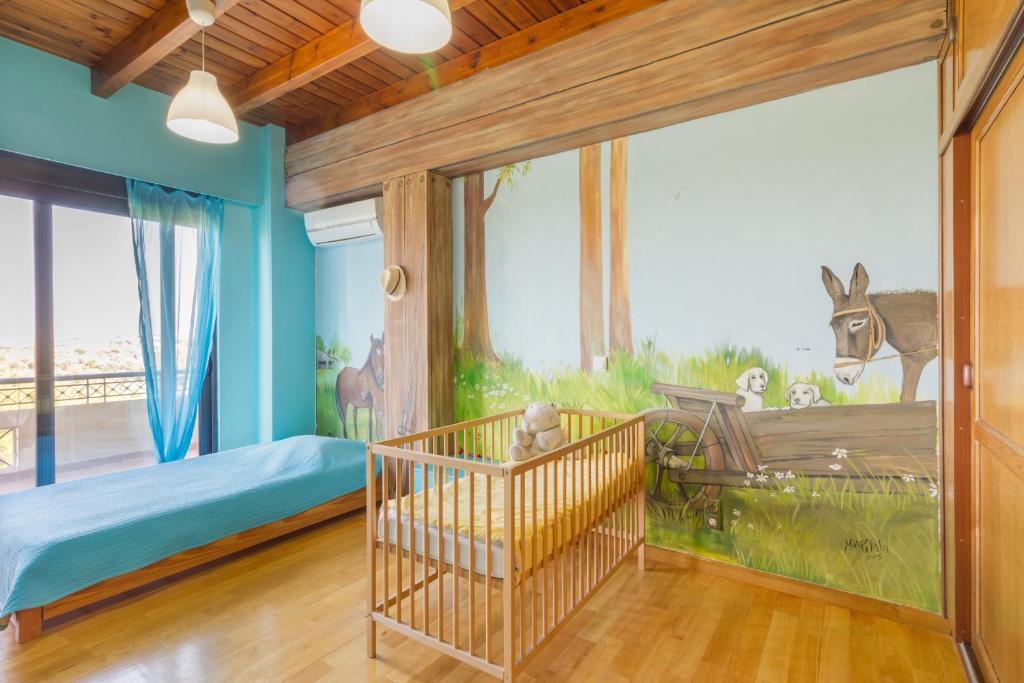 een kamer met een wieg en een muurschildering van een giraffe bij Elena's Country Home & SPA in Kalithies