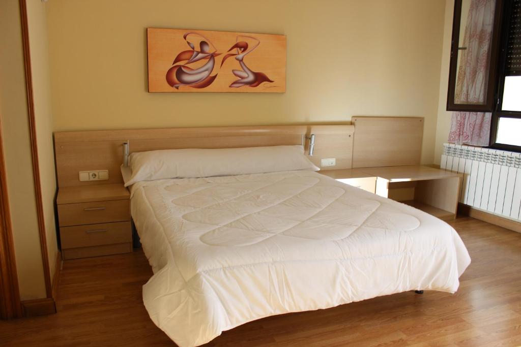 een slaapkamer met een bed en een schilderij aan de muur bij Hostal San Isidro in Autol