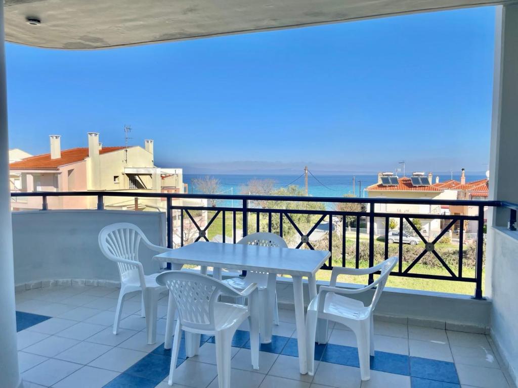 una mesa y sillas en un balcón con vistas al océano en Sueño beach hotel, en Polychrono