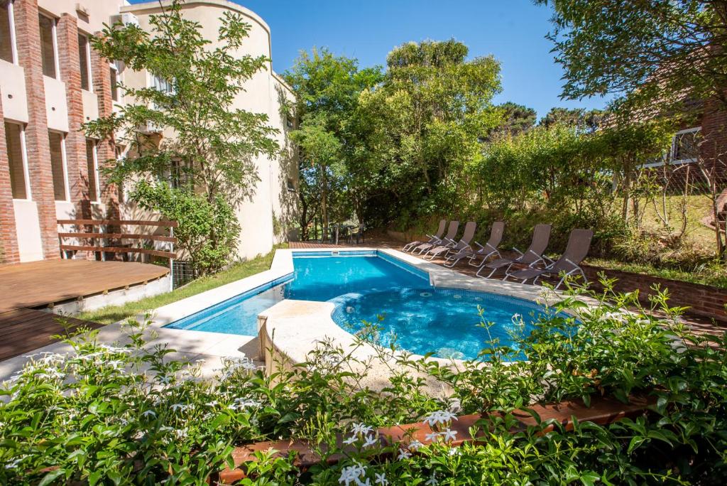 una piscina en un patio con sillas y un edificio en Hotel Viña del Mar en Ostende