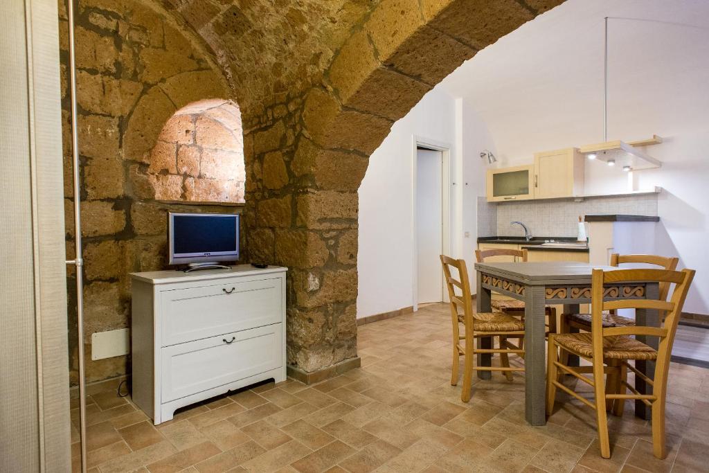 cocina y comedor con mesa y TV en Appartamento per Vacanza La Fontanella, en Orvieto