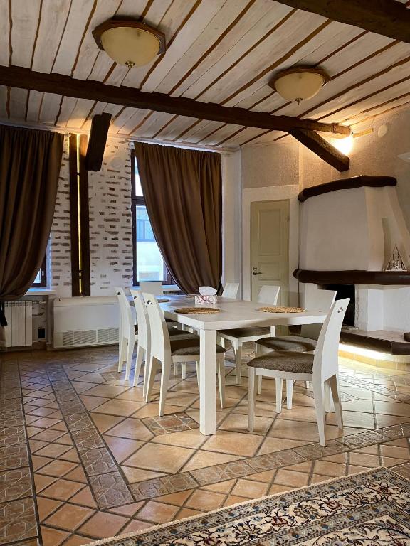 uma sala de jantar com uma mesa e cadeiras brancas em Атмосферные апартаменты с сауной и видом на парк em Vyborg