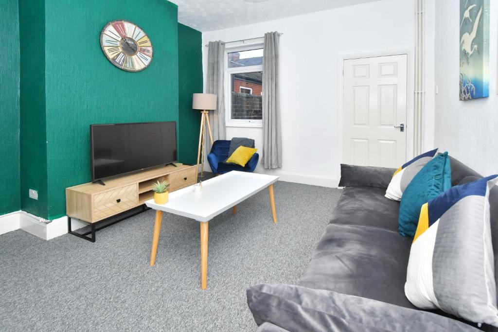 a living room with a couch and a tv at The Yellow Door by Avenew Management Serviced Accommodation in Stoke on Trent