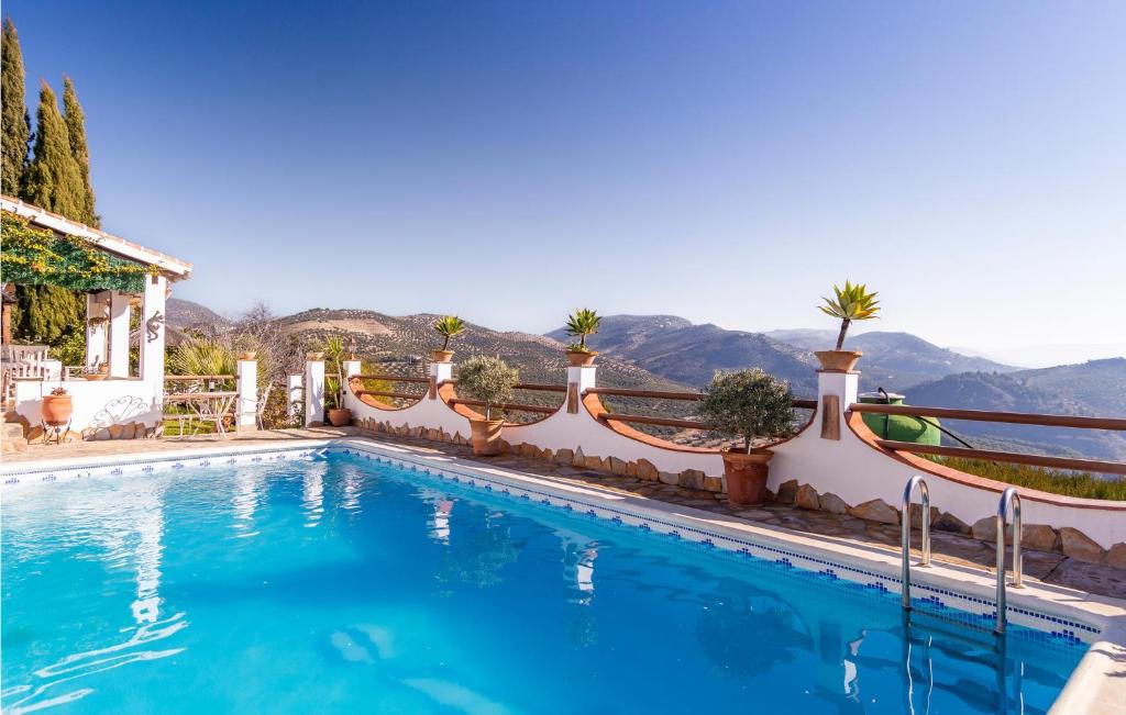 a swimming pool in front of a house with mountains in the background at Cozy Home In Iznajar With Swimming Pool in Iznájar