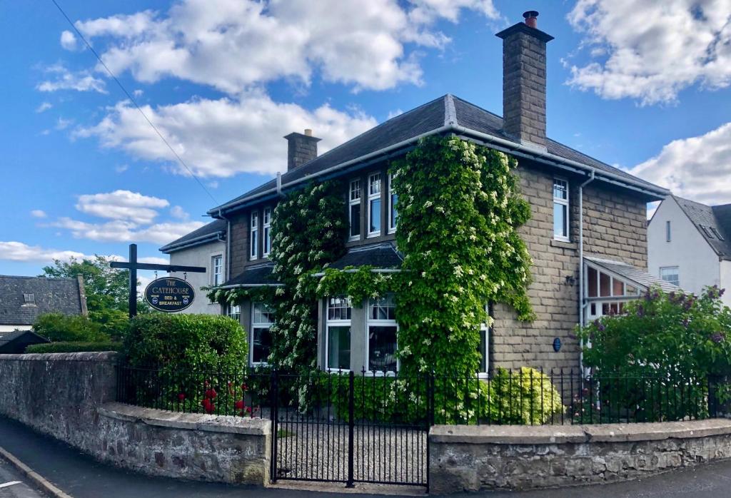 una casa con hiedra creciendo a su lado en The Gatehouse B&B en Inverness