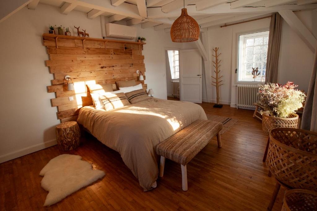 a bedroom with a large bed and a wooden wall at NAMASTE COTTAGE in Issigeac