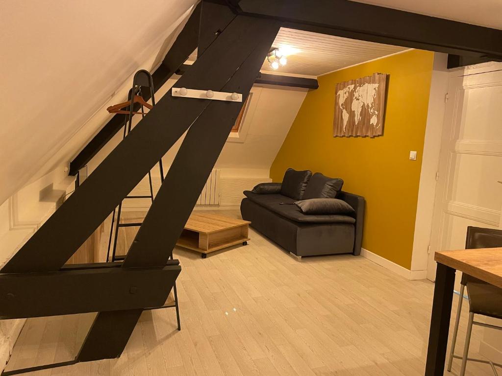 ein Wohnzimmer mit einem Sofa und einer Treppe in der Unterkunft Le petit paradis in Outreau