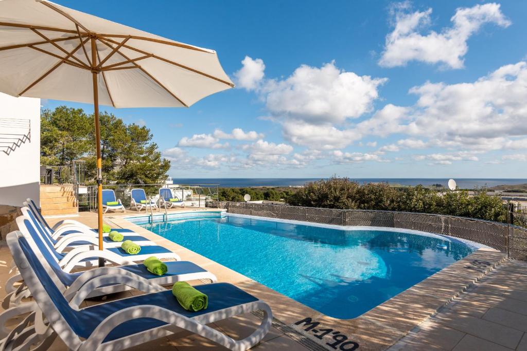 einen Pool mit Liegestühlen und einem Sonnenschirm in der Unterkunft Villa Gill in Punta Grossa