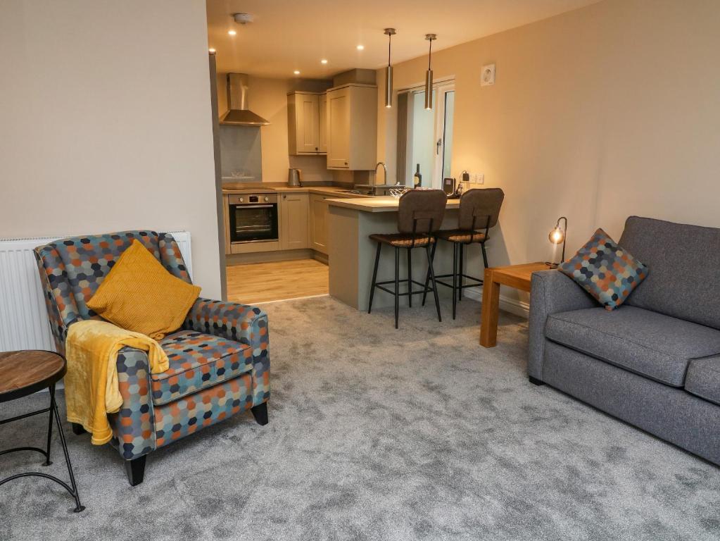 uma sala de estar com um sofá e uma cozinha em Market Lounge em Clitheroe