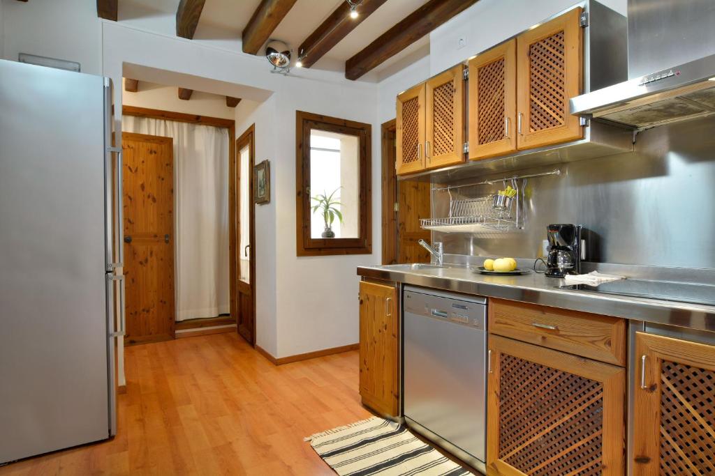 a kitchen with stainless steel appliances and wooden cabinets at Ramón Llull House in Palma de Mallorca