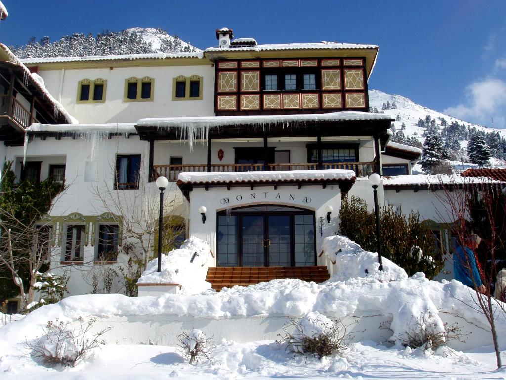 a house with snow on the ground in front of it at HOTEL SPA MONTANA in Karpenision