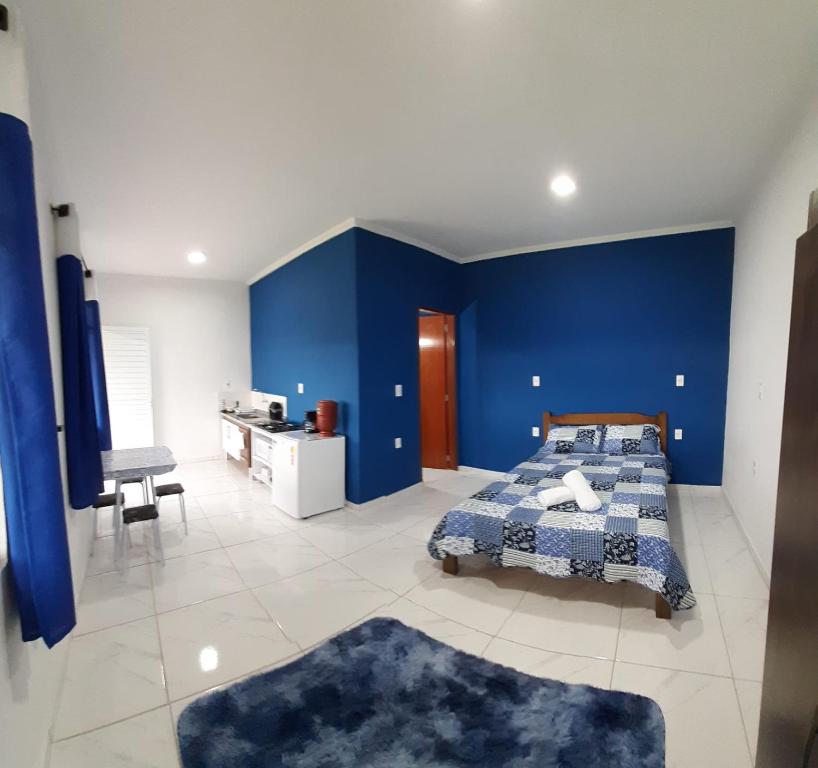 um quarto azul com uma cama e uma parede azul em Recanto em Cores - Chalé com uma linda vista para as montanhas em Córrego do Bom Jesus